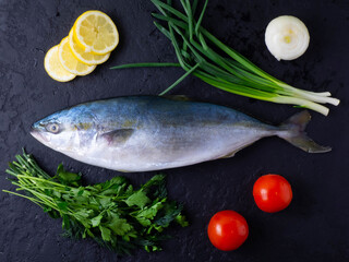 Whole raw fish tuna on a black table