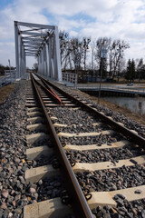 Obraz premium A close-up on rails and a railway bridge. Perspective photo taken on a sunny day.