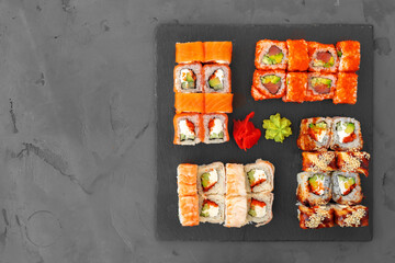 Set of sushi rolls served on gray background