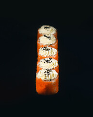 classic Philadelphia rolls in smoked salmon. japanese sushi on black background.