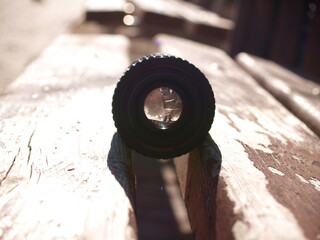 close up photo of old camera lens over wooden table. image is retro filtered. selective focus