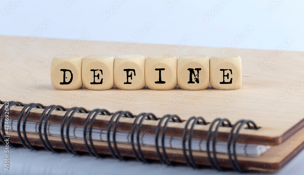 Poster word define made with letters on wooden blocks on wooden notepad