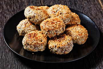 sesame lamb patties on a black plate