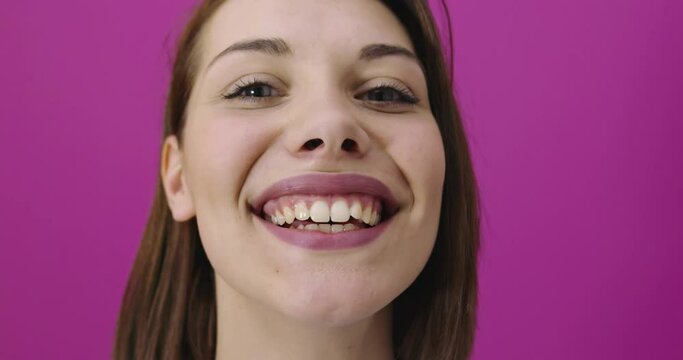 Positive woman smiling over pink backgorund