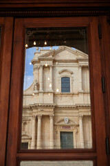 The Cathedral of San Nicolò in Noto is the cathedral of the Diocese of Noto of the ecclesiastical region of Sicily, founded in 1844. Part of the church to be seen in a window reflection. 