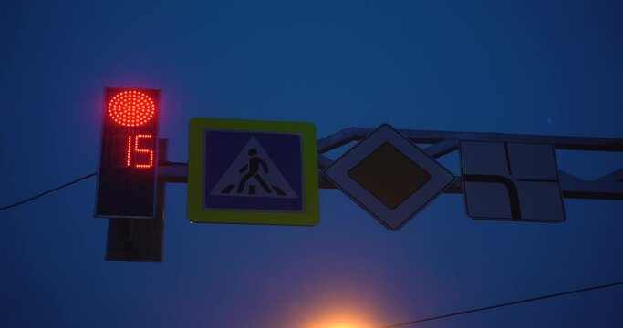 Traffic Signal at Night -- Stop and Go. Red and Green lights on a signal. 4K video. Traffic lights and road signs. Big city