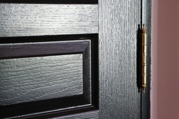 Closeup detail of black door, Gold Door Hinges