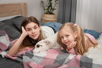 Teenage girl and child playing with their dog