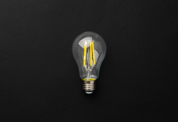 One light bulb on black background top view