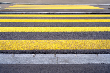 Close-up yellow zebra crossing empty early in the morning, Zurich, Switzerland.