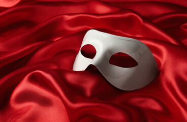 White plastic theatre mask on red fabric