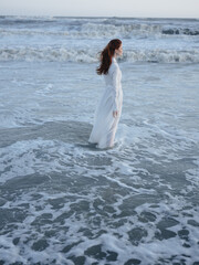 Romantic Woman in White Wedding Dress on the Beach by the Ocean