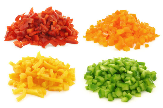 Red, orange, yellow and green brunoise cut blocks of bell pepper on a white background