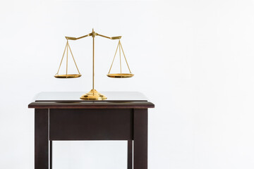 Balance scale of justice on wood table over white background. The scales made of brass or bronze,...