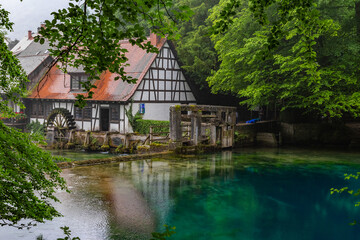 Fototapeta na wymiar Touristic highlight Blautopf in the old town of Blaubeuren in german region swabian alb