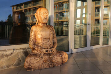 Buddha - a decorative wooden statue near the glass doors.