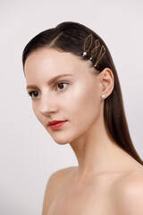 portrait of a girl, hair parted and pinned up with golden geometric hairpins in a minimalist design, studio catalog shooting on a white background, Korean and Chinese jewelry concept