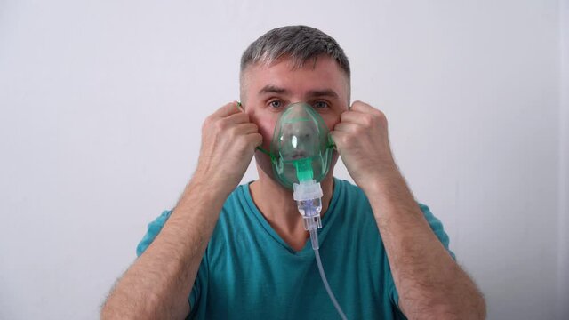 Male puts on an oxygen mask and self isolates from COVID-19 Pandemic.