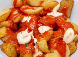 Primer plano de una racion de patatas picantes españolas en un restaurant de lujo