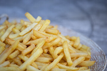Large plate of fries. A plate of potatoes is on the table. Quick snack and junk food concept