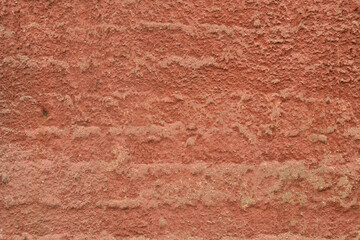 Red-orange painted wall with cinder block texture. Abstract interior background.