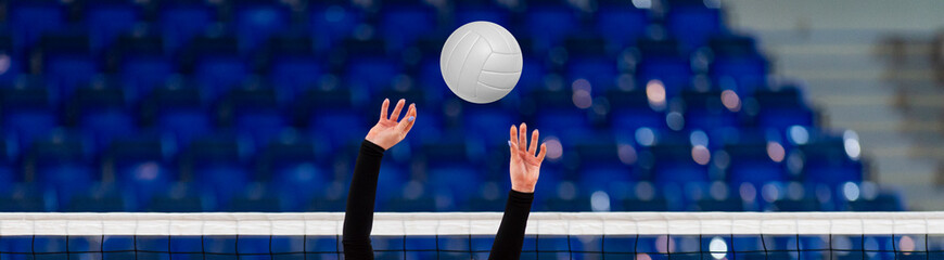 Girl Volleyball player and setter setting the ball for a spiker during a game. Professional sport concept