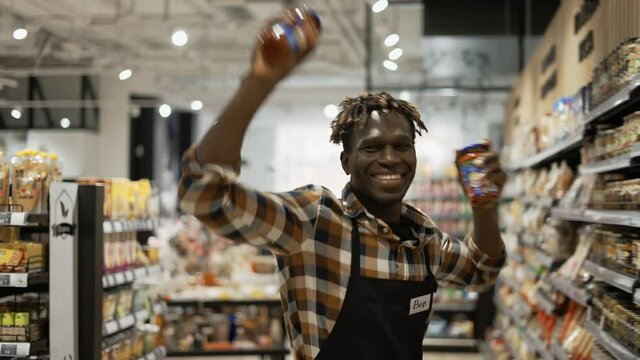 Handsome face seller man dancing with food items in hands