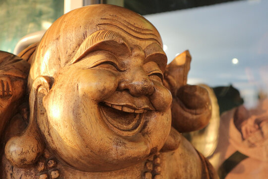 Hotei or the laughing Buddha is a wooden statue.