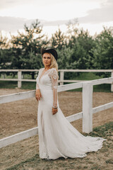 Fototapeta na wymiar Portrait of the bride. A beautiful woman in white wedding dress in bohemian style. Sunset