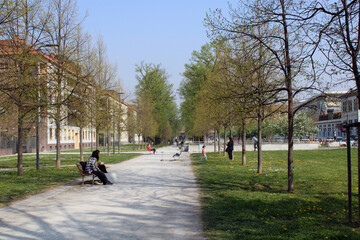 Obraz premium Parco di Miilano con alberi panchine e persone con mascherina anti Covid