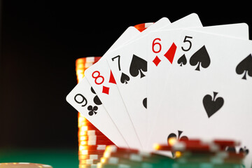 Poker chips and playing cards on black background
