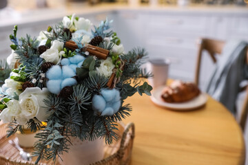Obraz na płótnie Canvas Beautiful winter bouquet on wooden table in kitchen, closeup