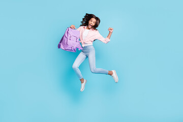 Fototapeta na wymiar Full size photo of young happe excited crazy good mood schoolgirl jump passed exams isolated on blue color background