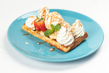 Waffle with ice cream cream banana strawberries on a plate