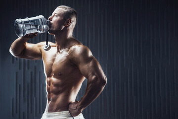 Fit man at workout in gym with shaker