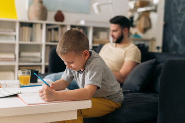 father and son at home. son do homework