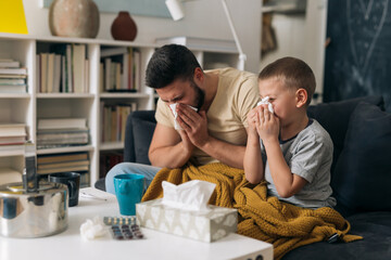 father and son catch a cold. they are sitting at home