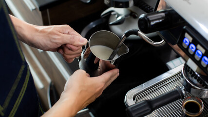 Close up hand holding Whipped cream with coffee. Making a cup of coffee in a coffee machine, the steam and the cup. Espresso maker machine with portafilter close up. Concept Coffee maker in cafe.