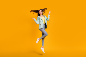 Fototapeta na wymiar Full length photo of pretty adorable young lady dressed turquoise jacket jumping rising arms isolated yellow color background