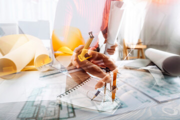 Two colleagues discussing data working and tablet, laptop with on on architectural project at construction site at desk in office