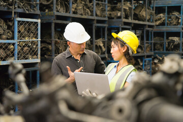 Man and woman work together, diversity of Asian engineer worker discuss with Caucasian manager in factory-warehouse