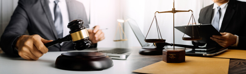 Business and lawyers discussing contract papers with brass scale on desk in office. Law, legal services, advice, justice and law concept picture with film grain effect