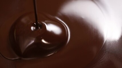 Pouring melted chocolate on the heart shaped chocolate