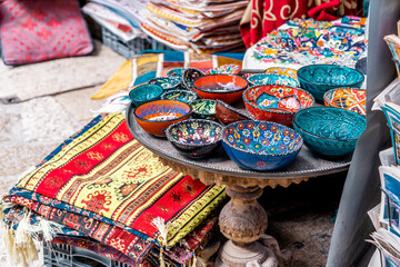 Fototapeta na wymiar Multicolored handmade bowls and colored rugs and shawls in the arab market (593)