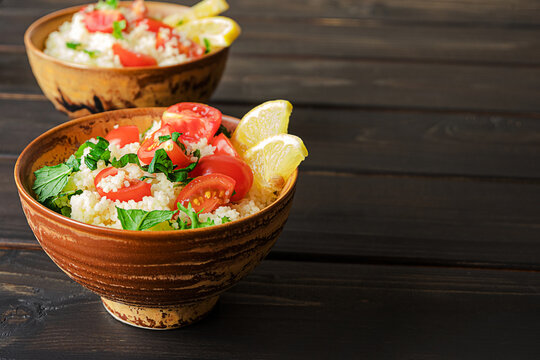 Fresh home-made tabouli, or tabbouleh salad, side view on dark wooden background, copy space