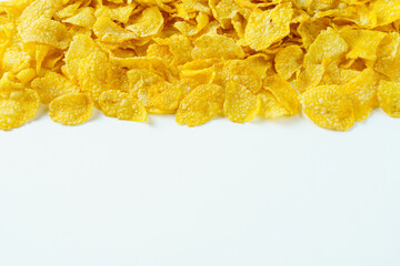 Yellow cornflakes with copy space in below on white background. Isolated food concept. Copy space.