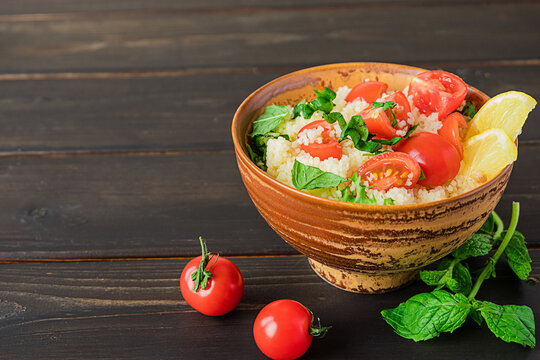 Fresh home-made tabouli, or tabbouleh salad, side view on dark wooden background, copy space