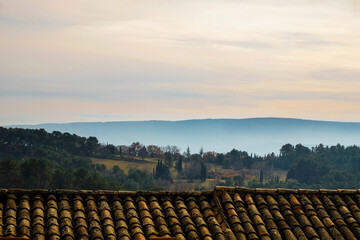 Blurred panorama of Provence at sunset. Old tiled roof. Roussillon tourist village. France. Copy...