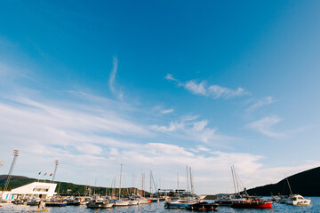 Motor boats and yachts at the boat station against the blue sky.