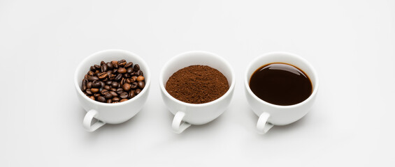 cups with prepared and ground coffee near beans on white, banner